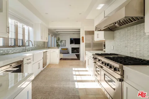 a large kitchen with stainless steel appliances granite countertop a stove and a sink