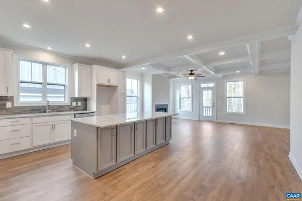 a large kitchen with stainless steel appliances granite countertop a large counter top and a wooden floors