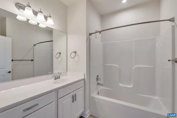 a bathroom with a bathtub a sink a large mirror and shower