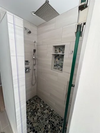 a bathroom with a granite countertop sink a mirror and a shower