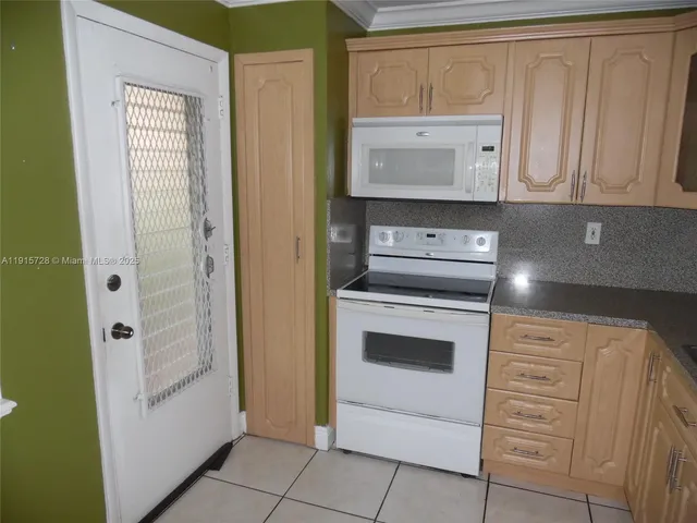 a kitchen with white cabinets and white appliances