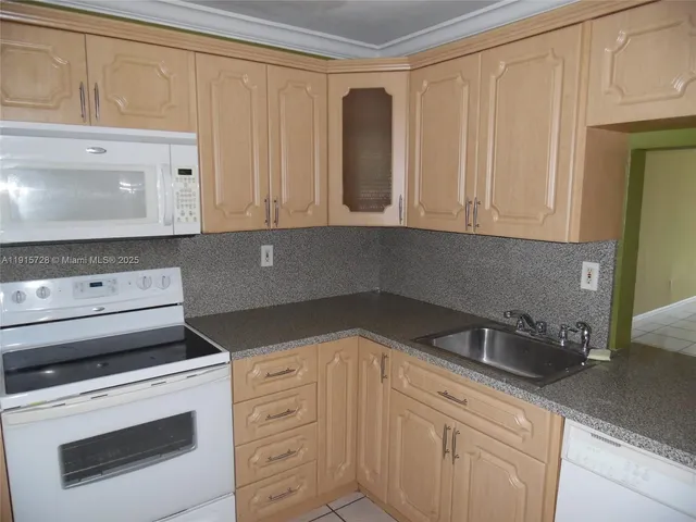 a kitchen with white cabinets and white appliances