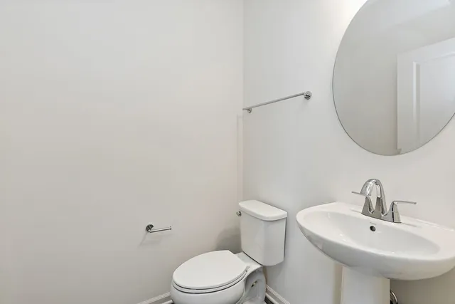 a bathroom with a sink a toilet and mirror