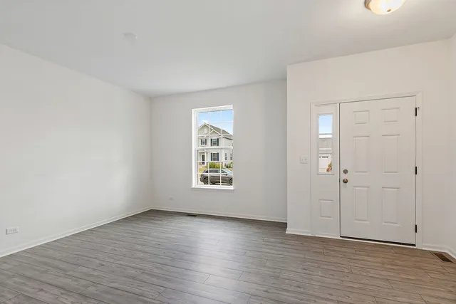 an empty room with wooden floor and window