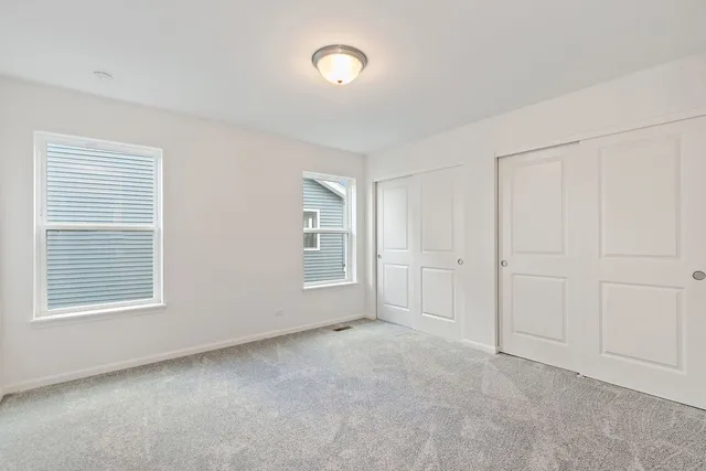 an empty room with windows and closet