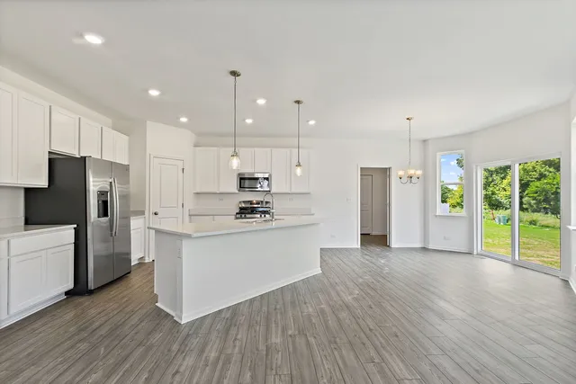a large kitchen with stainless steel appliances refrigerator sink and cabinets
