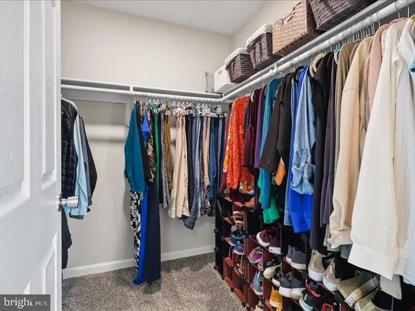 a view of walk in closet with clothes