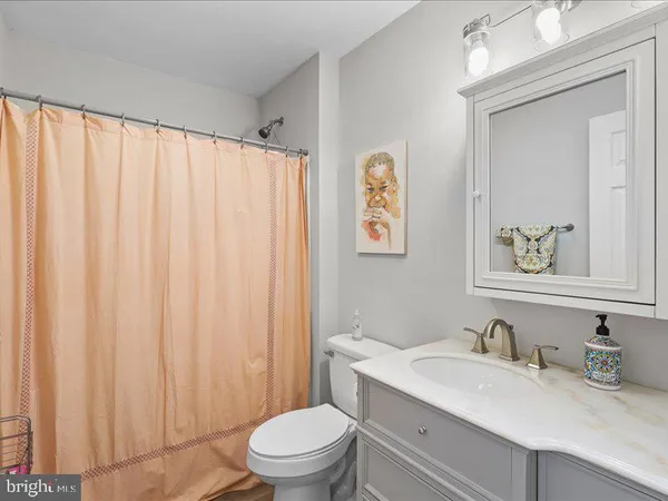 a bathroom with a sink vanity mirror and toilet