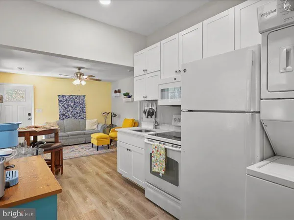 a kitchen with stainless steel appliances a refrigerator a stove a sink dishwasher and white countertops with wooden floor