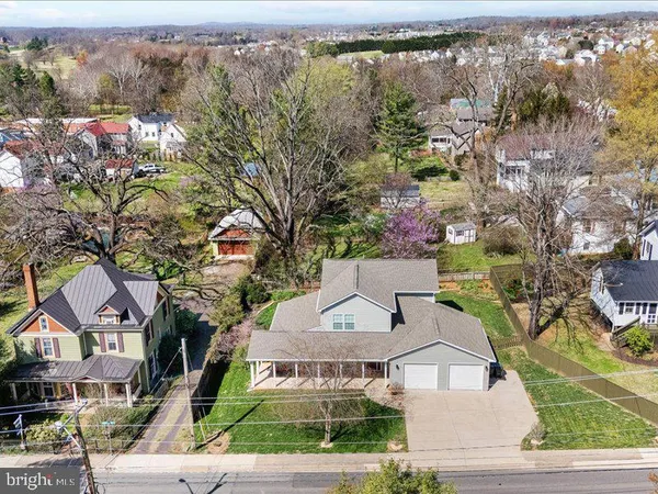 an aerial view of residential houses with outdoor space and trees
