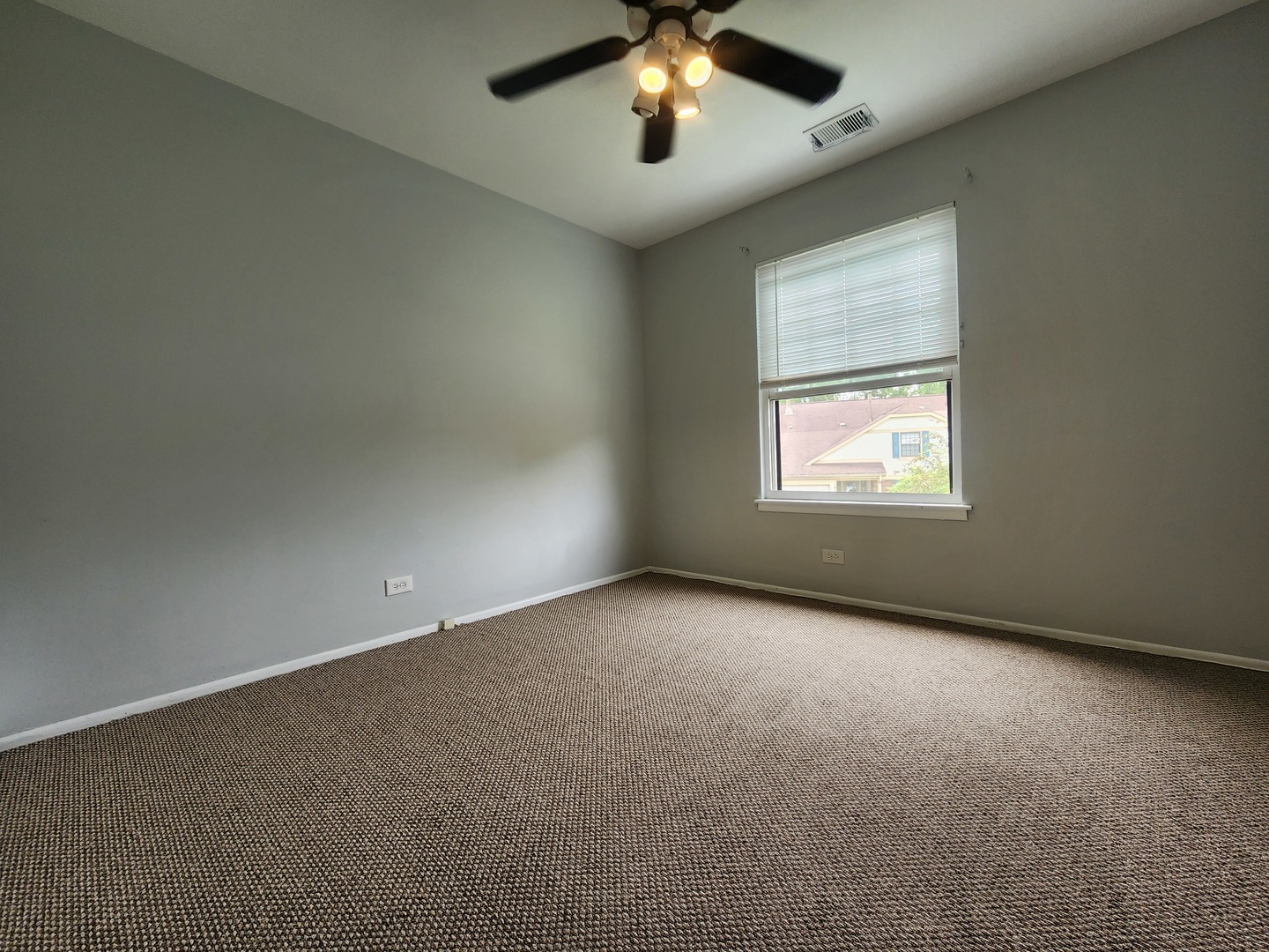 1020 Boxwood Court, Unit C2 Wheeling, IL 60090 - Photo 13 of 21 an empty room with a chandelier fan and windows
