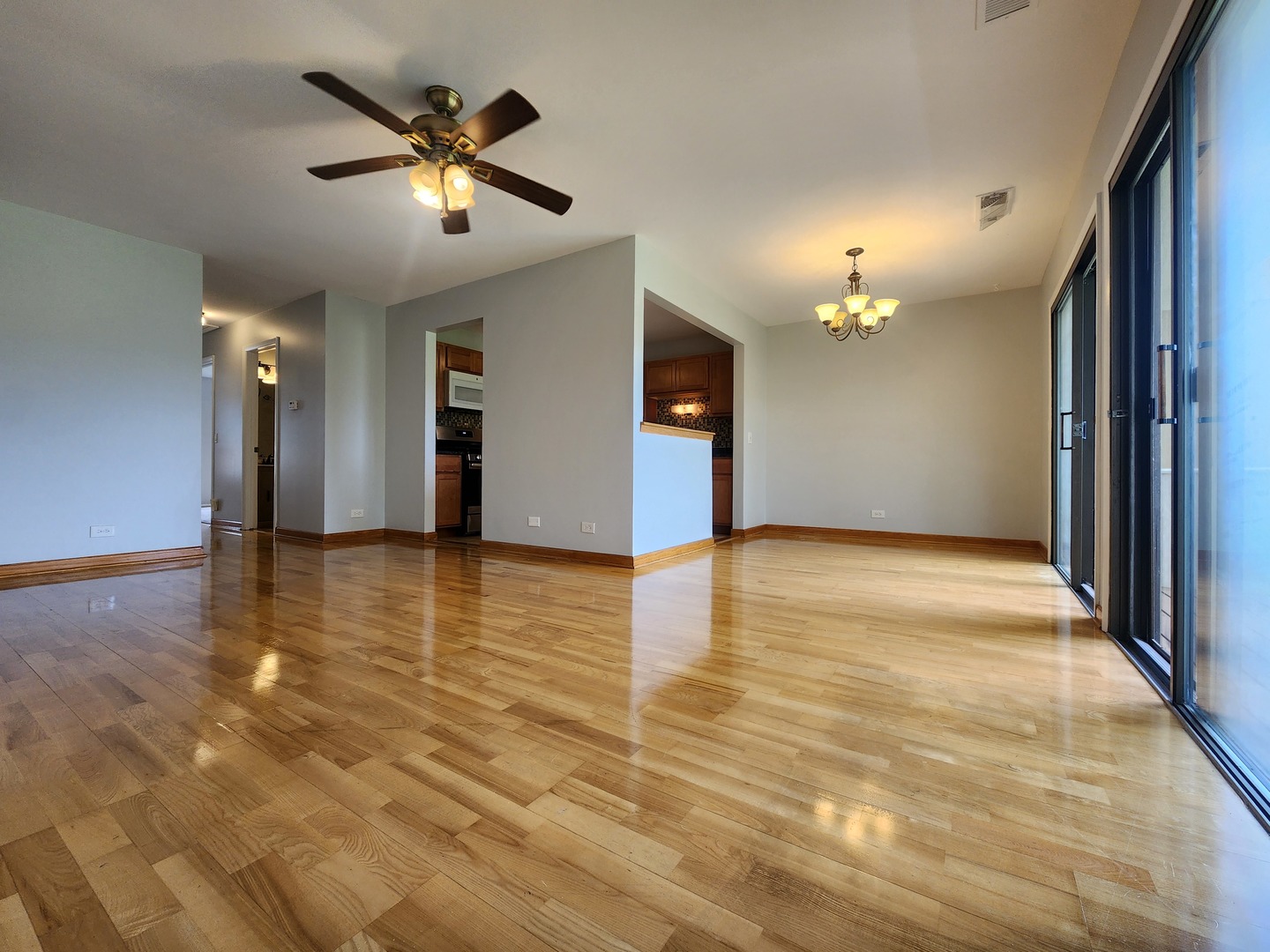 1020 Boxwood Court, Unit C2 Wheeling, IL 60090 - Photo 2 of 21 a view of an empty room with wooden floor and a ceiling fan