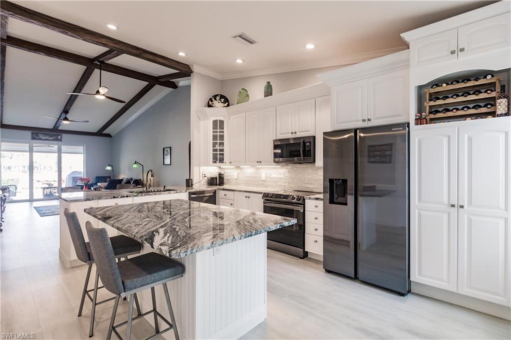 a kitchen with stainless steel appliances granite countertop a stove refrigerator and a refrigerator
