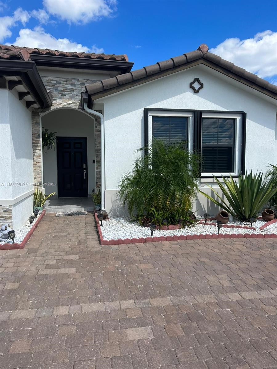 12829 Southwest 228th Street, Unit 2 Miami, FL 33170 - Photo 2 of 23 a view of a house with a yard and plants