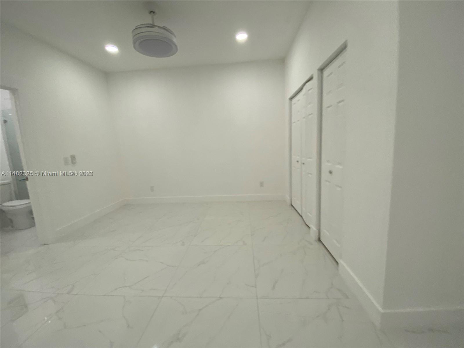 12829 Southwest 228th Street, Unit 2 Miami, FL 33170 - Photo 22 of 23 an empty room with a hallway and wooden shelves