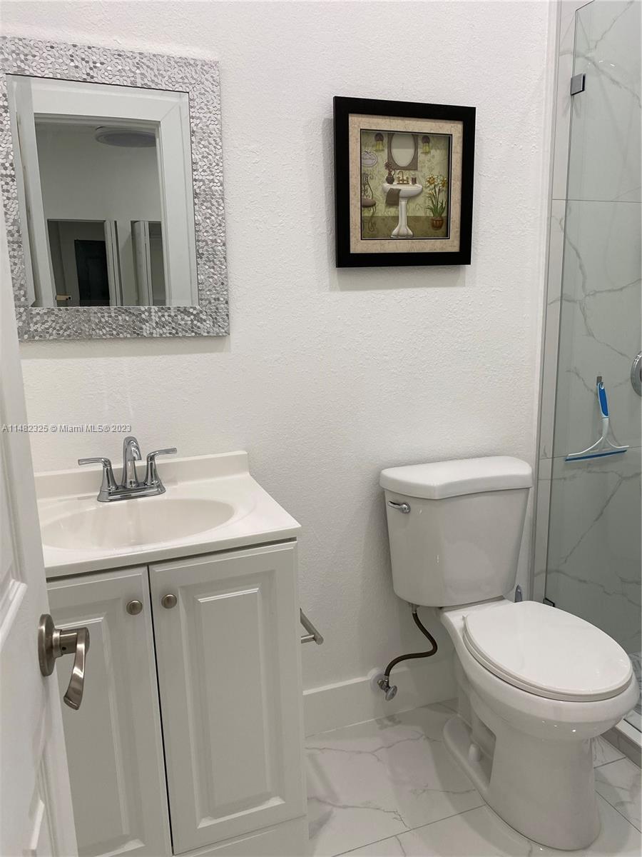 12829 Southwest 228th Street, Unit 2 Miami, FL 33170 - Photo 7 of 23 a bathroom with a toilet a sink and mirror