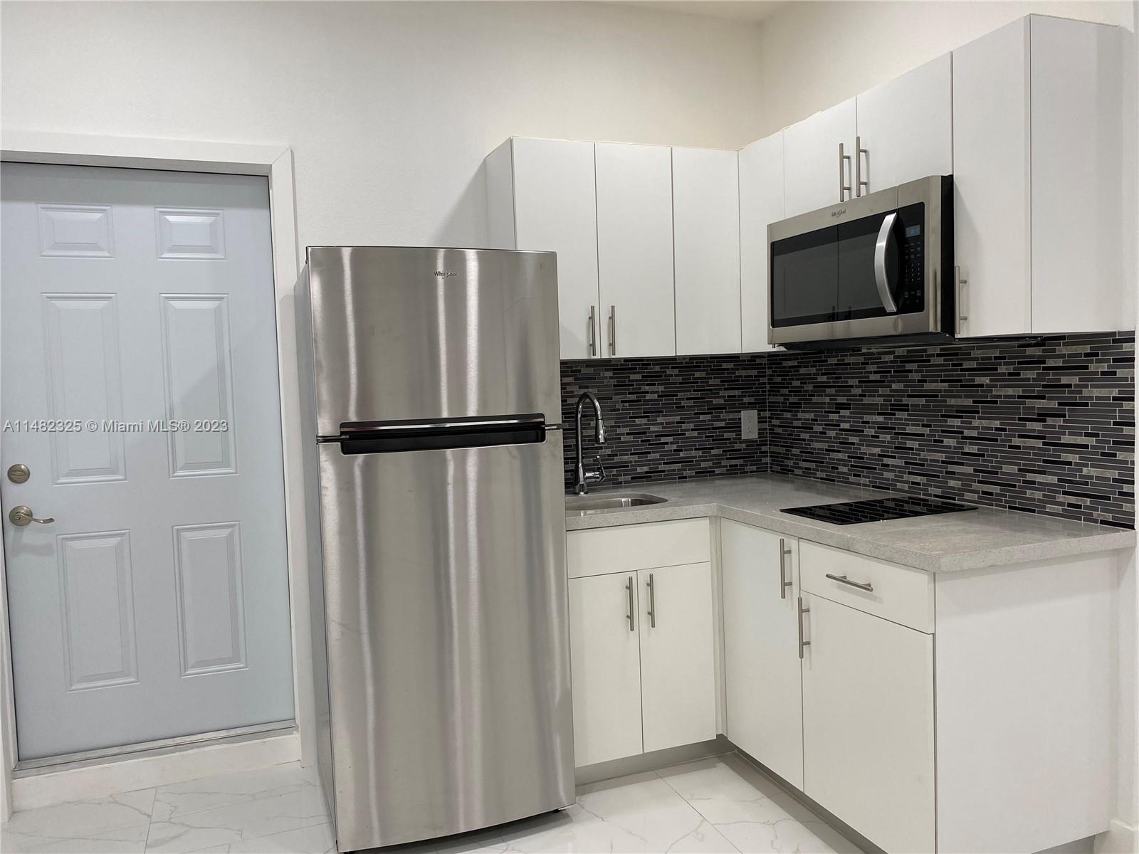 12829 Southwest 228th Street, Unit 2 Miami, FL 33170 - Photo 9 of 23 a kitchen with stainless steel appliances granite countertop a refrigerator and a stove top oven