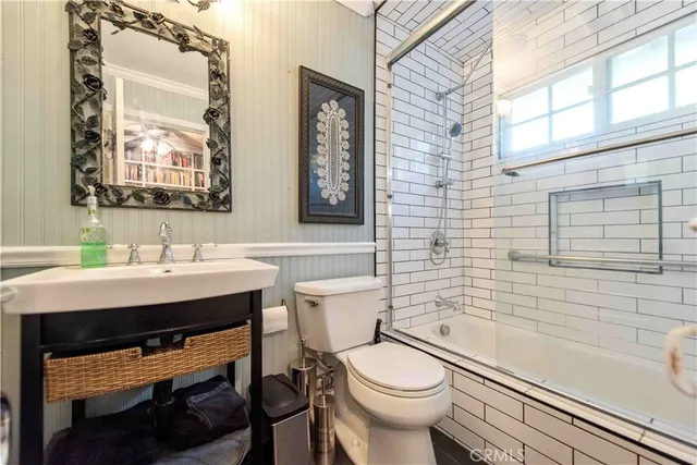 a bathroom with a sink a toilet a mirror and a tub