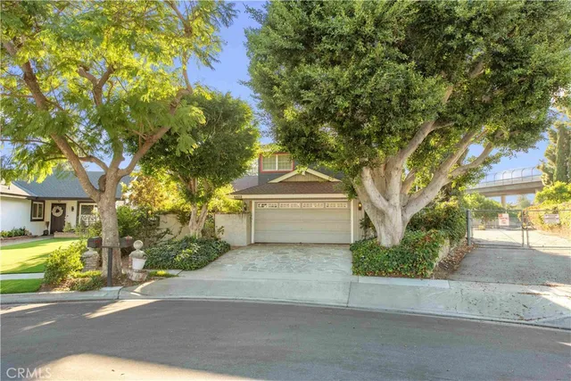 a white house that has a tree in front of it