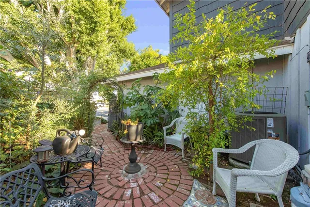 a backyard with table and chairs and potted plants