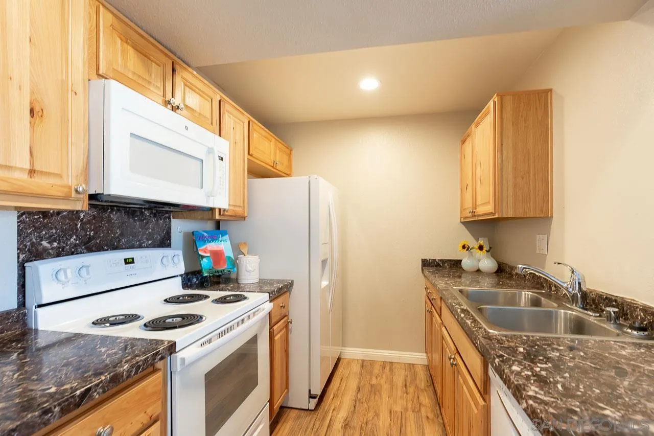 6171 Rancho Mission Road, Unit 208 San Diego, CA 92108 - Photo 1 of 18 a kitchen with granite countertop a sink a stove and refrigerator