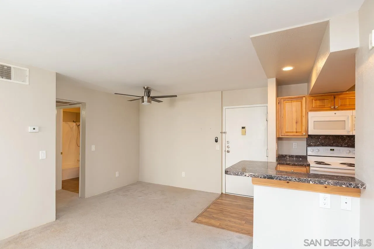 6171 Rancho Mission Road, Unit 208 San Diego, CA 92108 - Photo 5 of 18 a view of a kitchen with a sink and a refrigerator