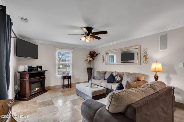 a living room with furniture a ceiling fan and a flat screen tv