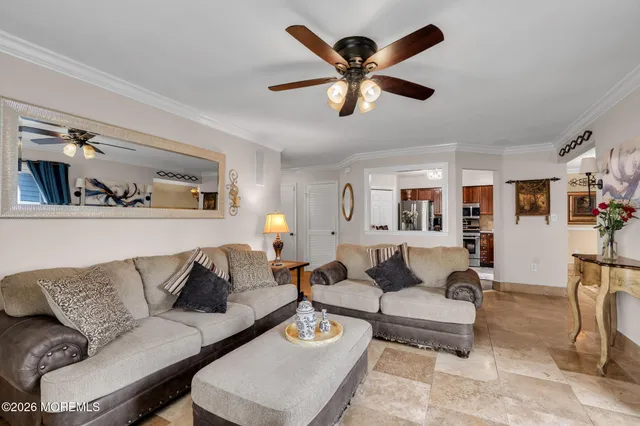a living room with furniture and a view of kitchen