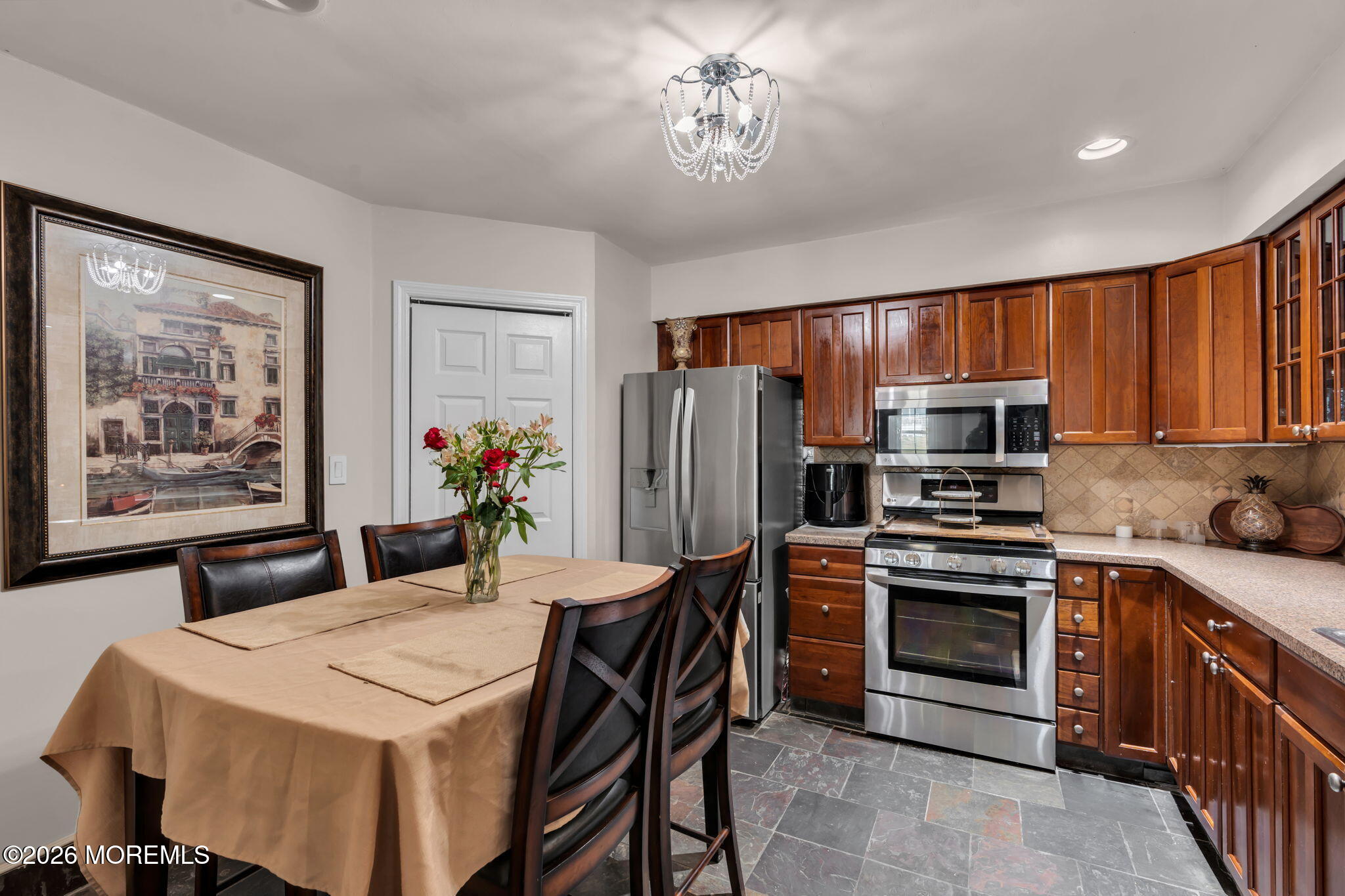 1 Breakwater Square Freehold, NJ 07728 - Photo 16 of 33 a kitchen with stainless steel appliances a stove a refrigerator a sink a stove a dining table and chairs