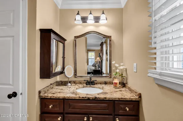 a bathroom with a granite countertop sink and a mirror