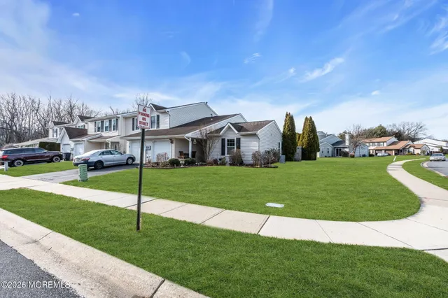 a view of a house with a big yard and large trees