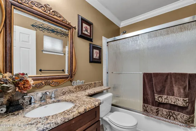 a bathroom with a granite countertop sink toilet a mirror and shower