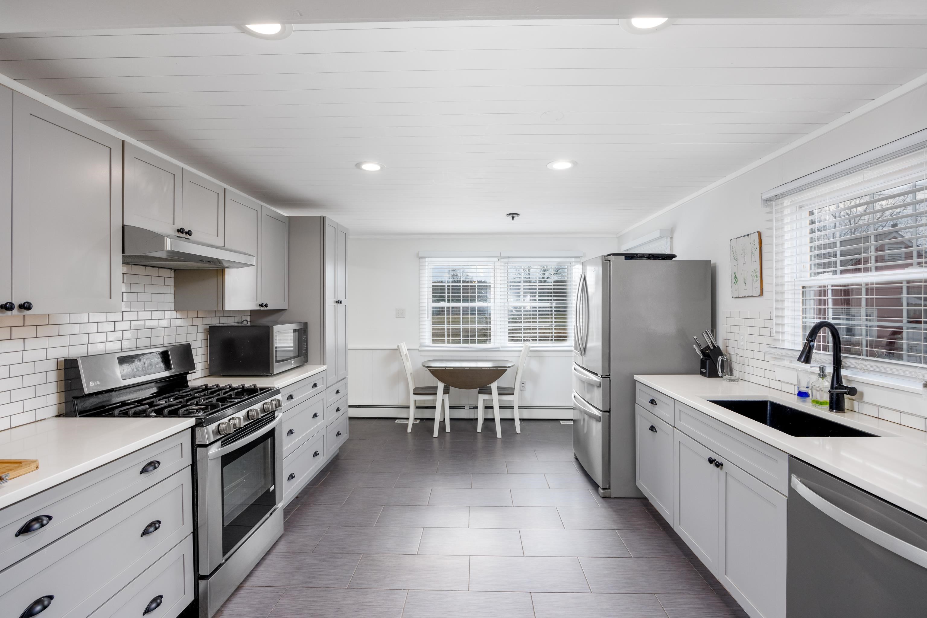 103 Bate Avenue Rio Grande, NJ 08242 - Photo 12 of 50 a kitchen with stainless steel appliances a stove a sink a microwave a refrigerator and cabinets