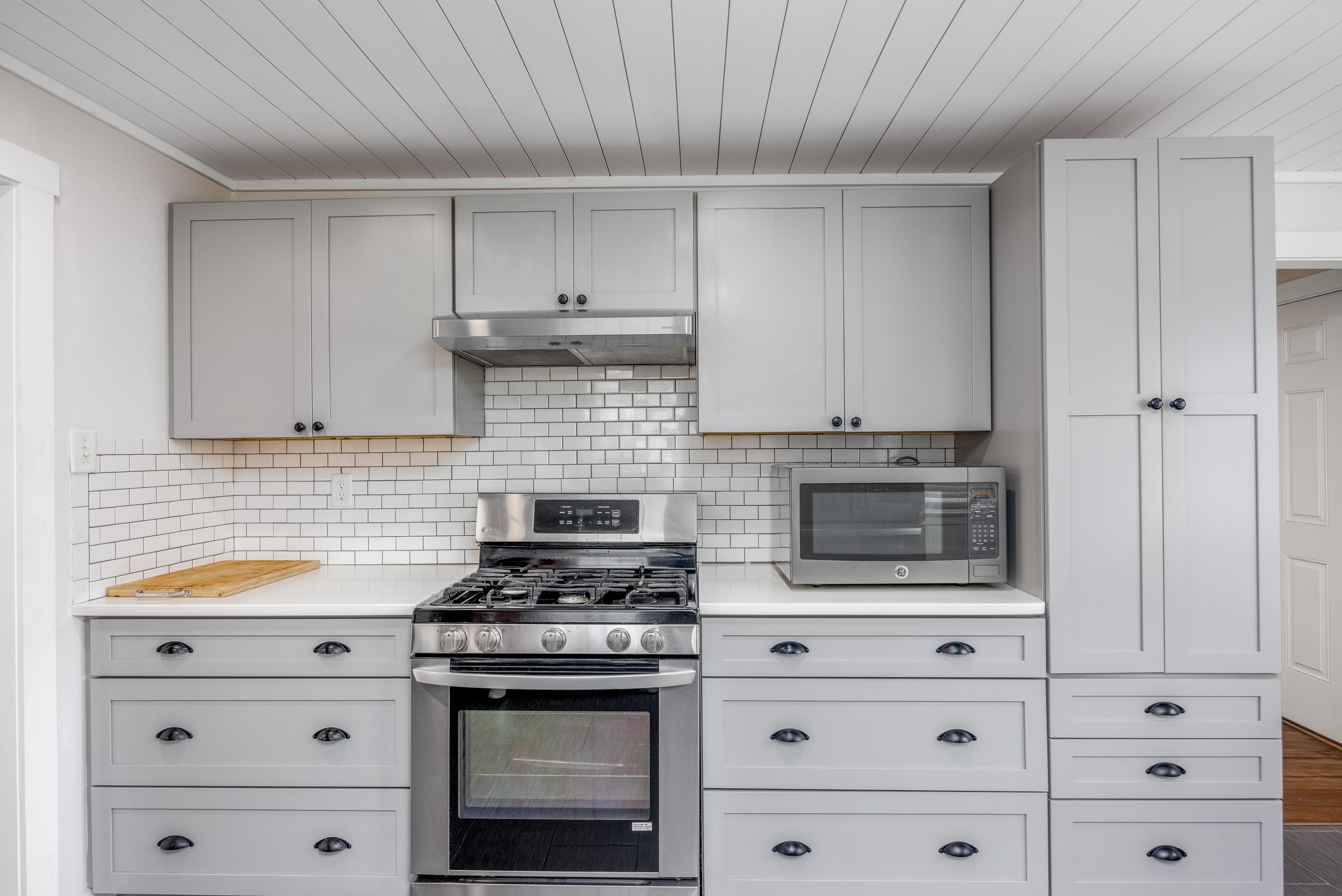 103 Bate Avenue Rio Grande, NJ 08242 - Photo 13 of 50 a kitchen with granite countertop white cabinets and stainless steel appliances