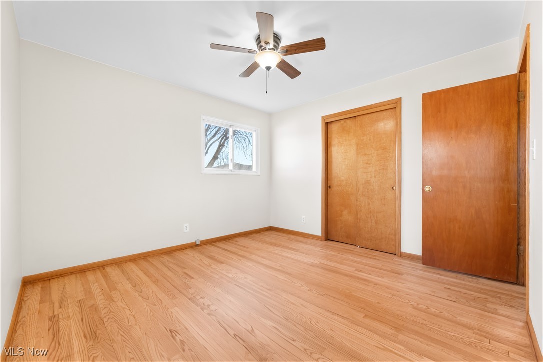 615 Ingalls Road Akron, OH 44312 - Photo 35 of 50 Unfurnished bedroom with a ceiling fan, light wood-type flooring, baseboards, and two closets