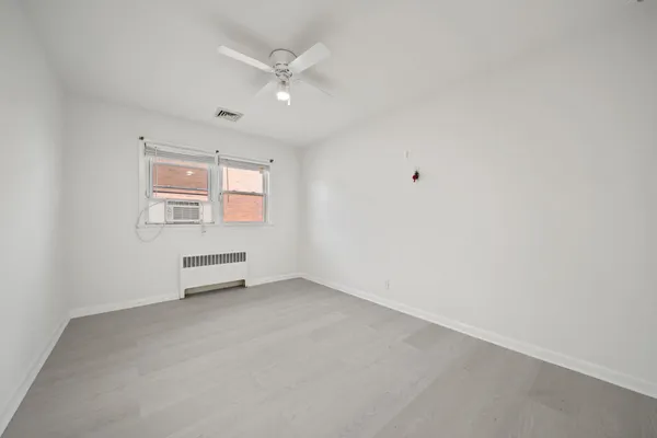 an empty room with a ceiling fan and a window