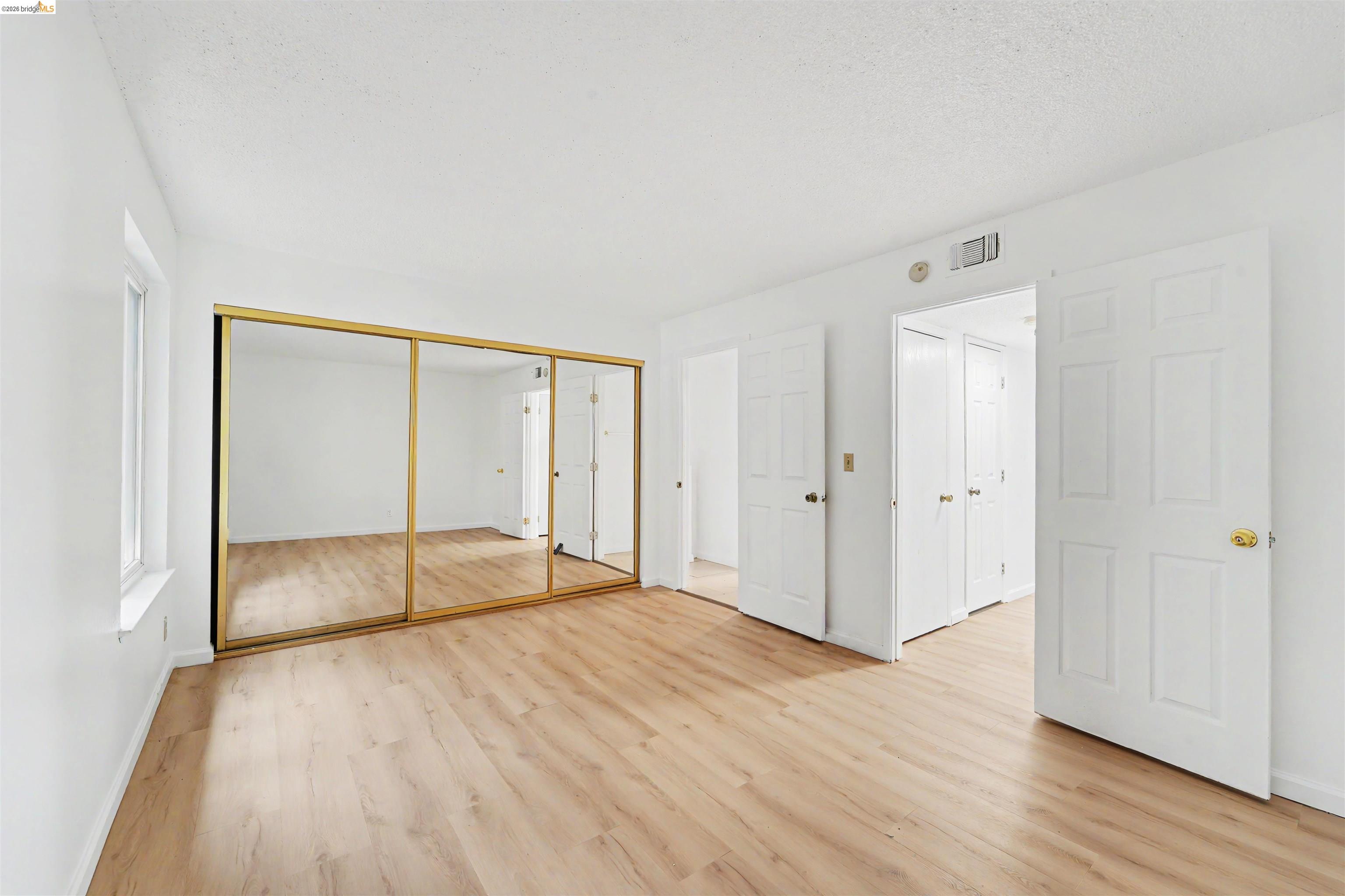 4186 San Pablo Dam Road, Unit A El Sobrante, CA 94803 - Photo 13 of 34 Room featuring wood-finish flooring, white walls, and a window with white trim