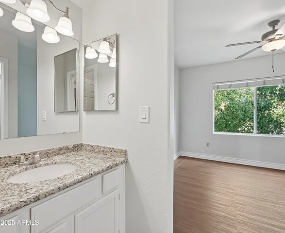 a bathroom with a granite countertop sink and a mirror
