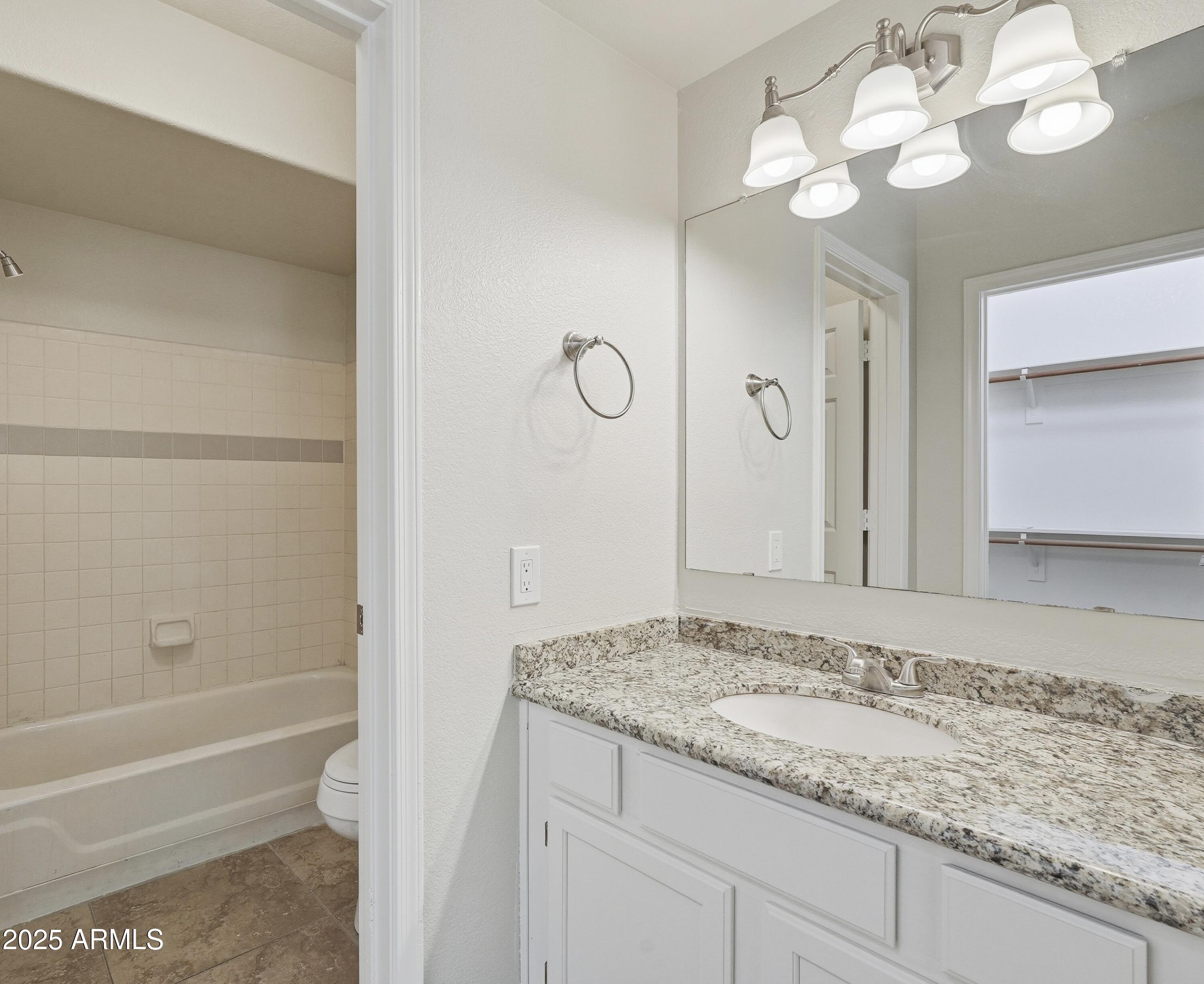 1825 West Ray Road, Unit 2145 Chandler, AZ 85224 - Photo 9 of 25 a bathroom with a granite countertop sink and a mirror