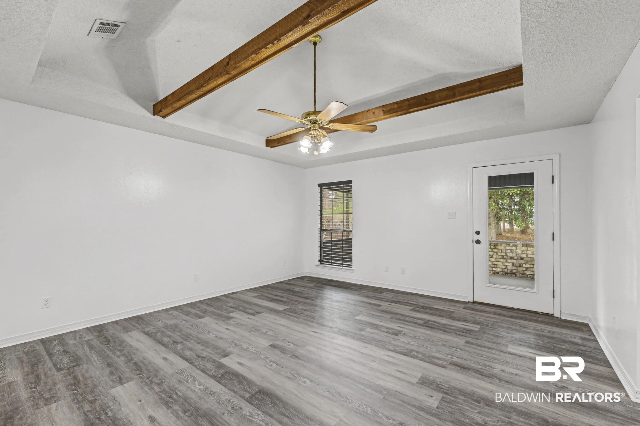 2776 Santa Rosa Circle Lillian, AL 36549 - Photo 14 of 48 Spare room featuring plenty of natural light, a textured ceiling, wood finished floors, a ceiling fan, and a raised ceiling