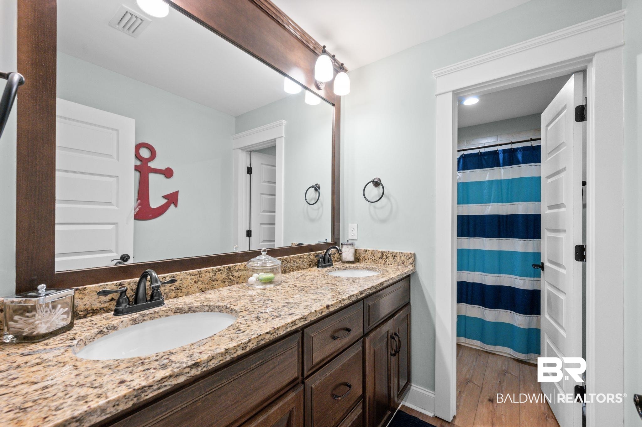 409 Fortune Drive Fairhope, AL 36532 - Photo 31 of 42 Bathroom featuring a dual vanity with granite-finish countertop, undermount sinks, and dark wood cabinetry