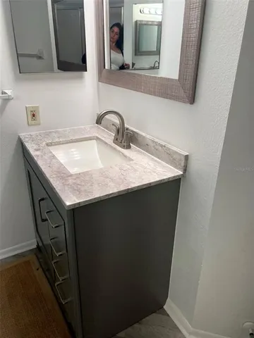 a utility room with a sink a mirror and vanity