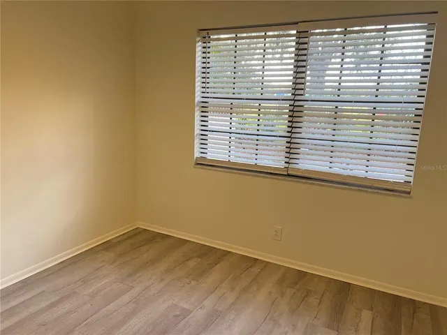 a view of a small space with wooden floor and a window