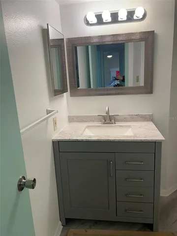 a bathroom with a sink vanity and a mirror