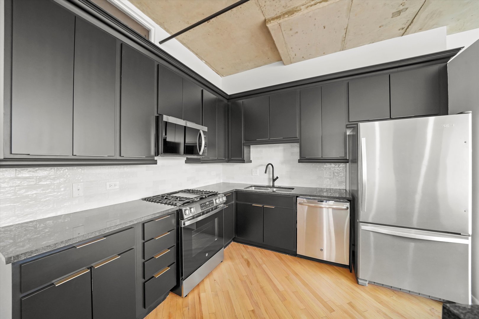 6 South Laflin Street, Unit 910 Chicago, IL 60607 - Photo 11 of 23 a kitchen with stainless steel appliances granite countertop a sink stove and refrigerator