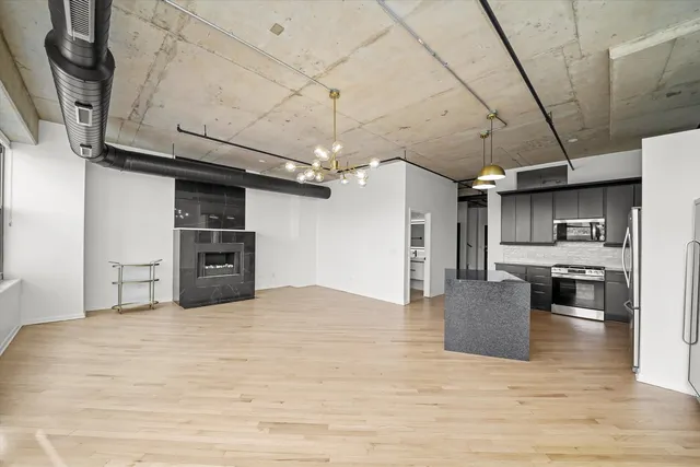 a large kitchen with stainless steel appliances kitchen island granite countertop a sink and cabinets