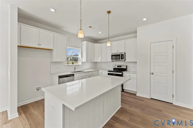 a kitchen with stainless steel appliances granite countertop a refrigerator a sink a stove a microwave and a refrigerator