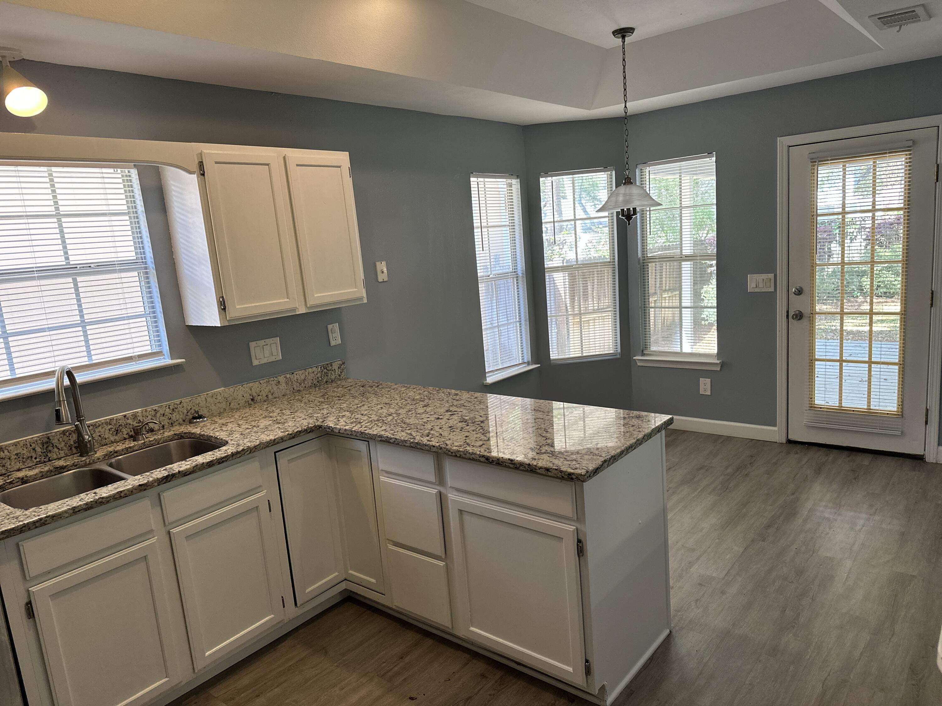 114 Wright Circle Niceville, FL 32578 - Photo 5 of 17 a kitchen with stainless steel appliances granite countertop a sink and cabinets with wooden floor