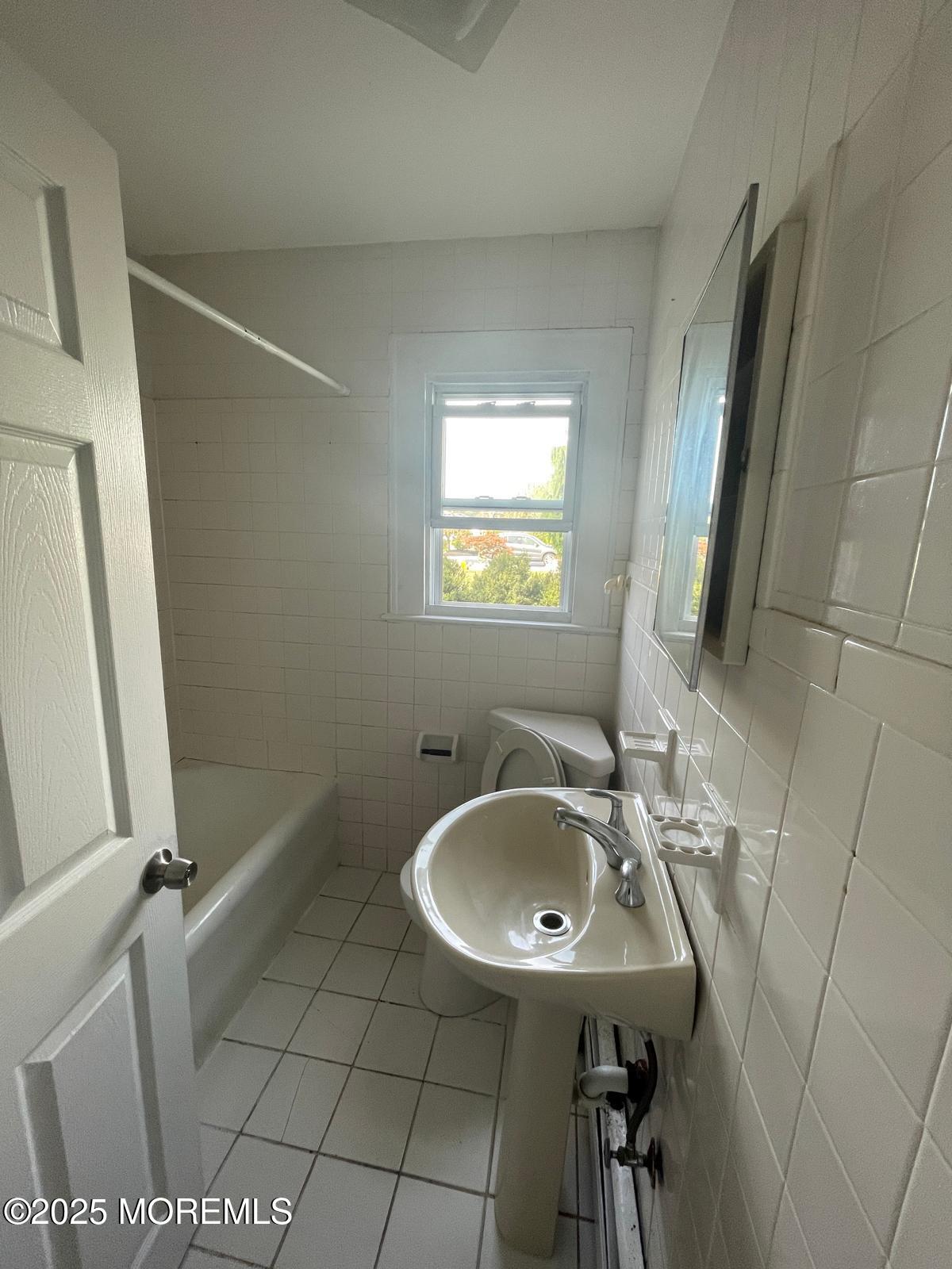 399 Park Avenue, Unit 1 Oakhurst, NJ 07755 - Photo 11 of 12 a bathroom with a sink a toilet and a mirror