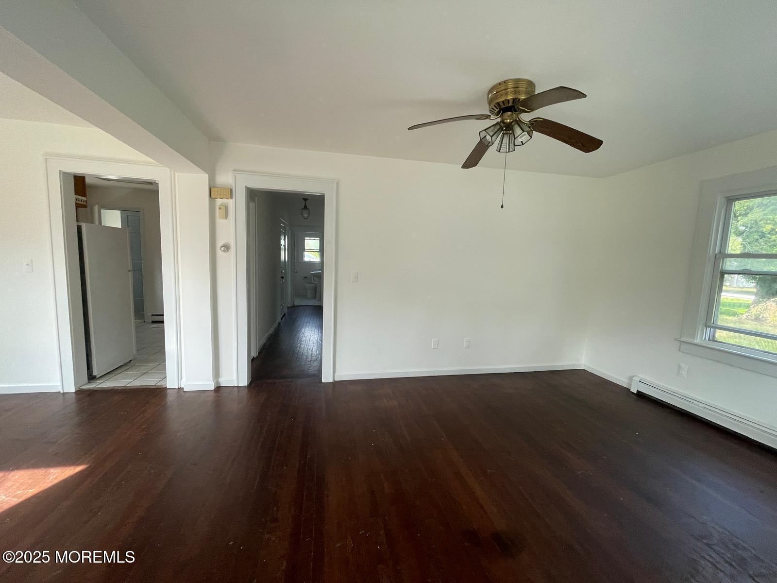 399 Park Avenue, Unit 1 Oakhurst, NJ 07755 - Photo 3 of 12 a view of empty room with wooden floor and fan